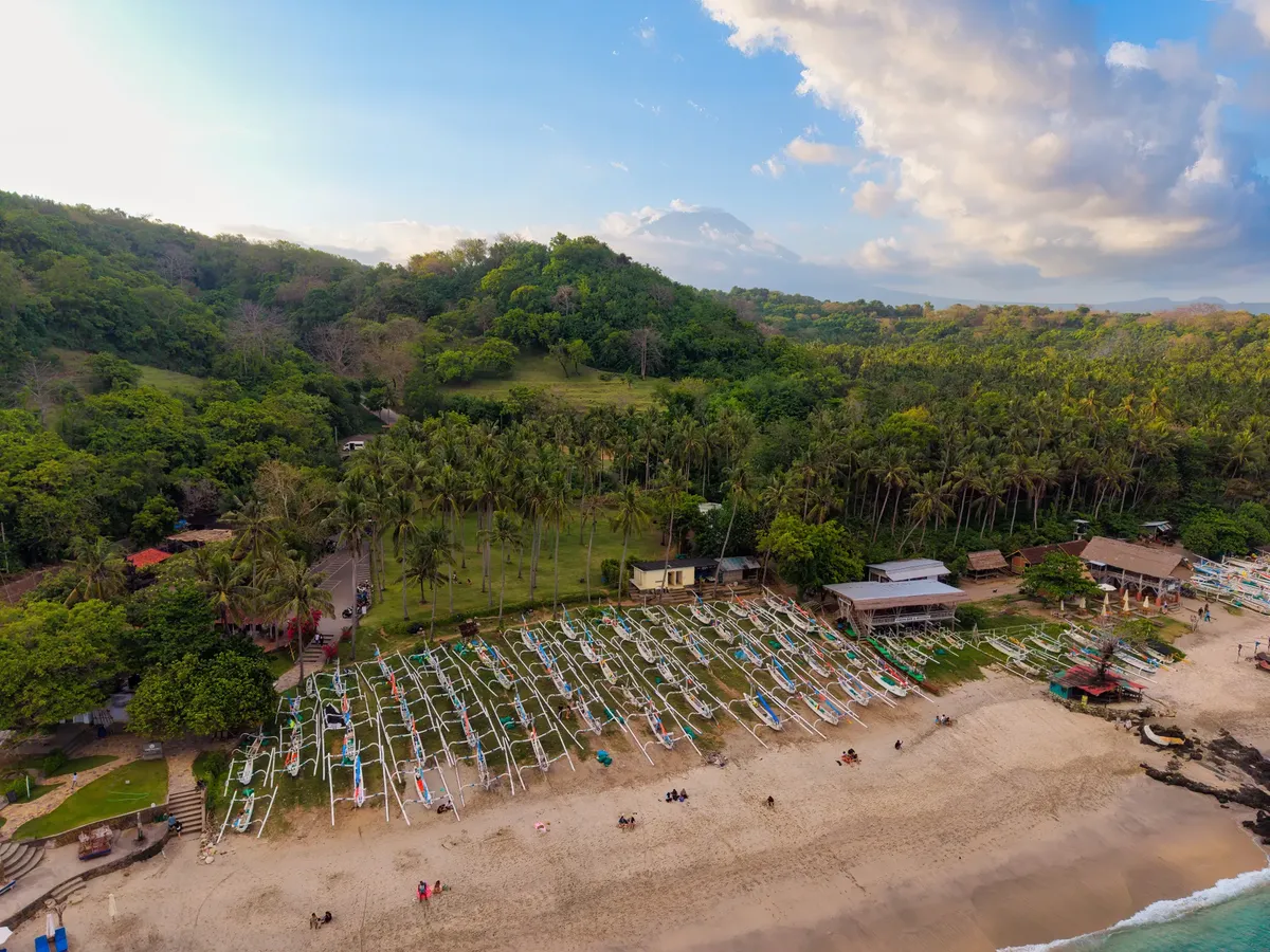 Breathtaking aerial shot of traditional fishing boats on a Bali beach.