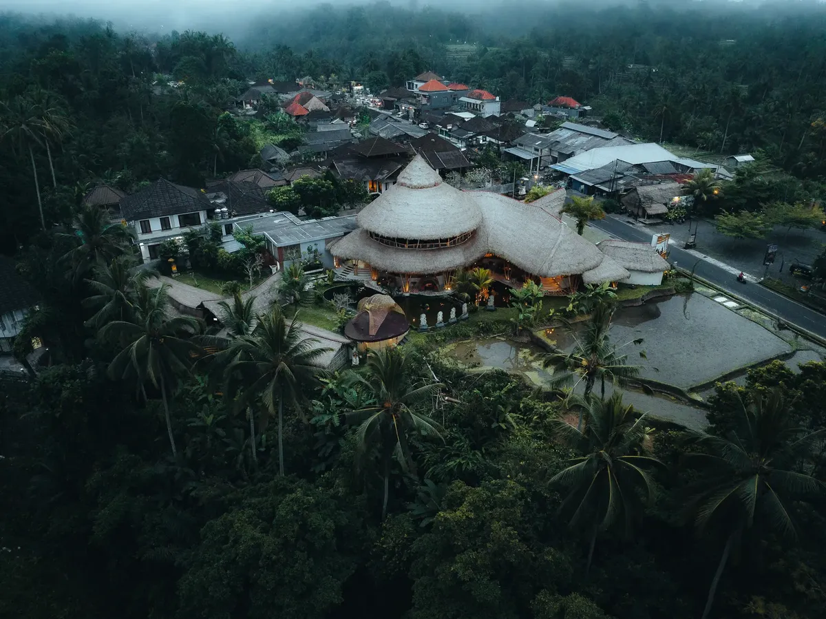 A stunning aerial view of a bamboo resort in Tegallalang, Bali, Indonesia, surrounded by lush greenery.